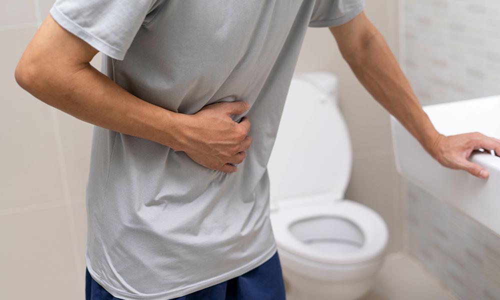 man holding stomach in restroom