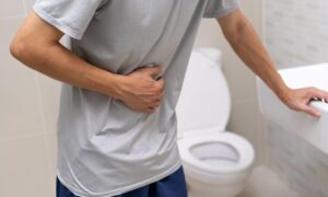 man holding stomach in restroom